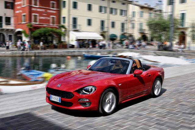 red fiat 124 spider driving in town
