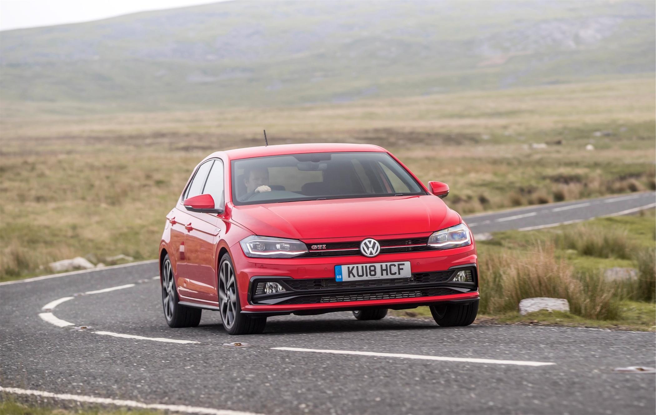 red volkswagen polo gti driving on a british country road