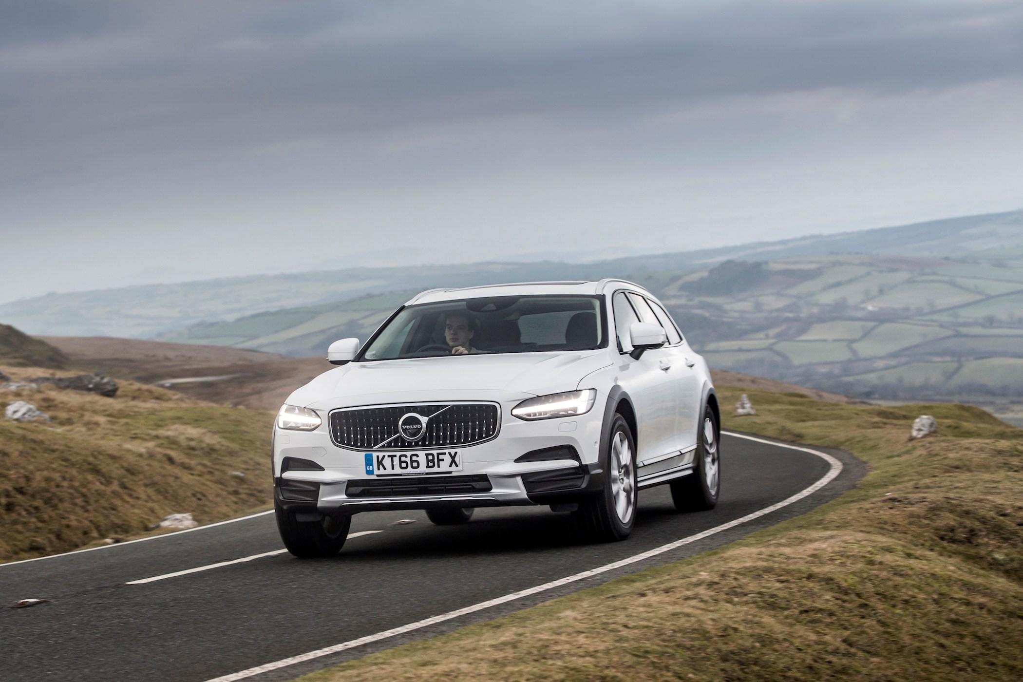 white volvo v90 estate driving on a country road