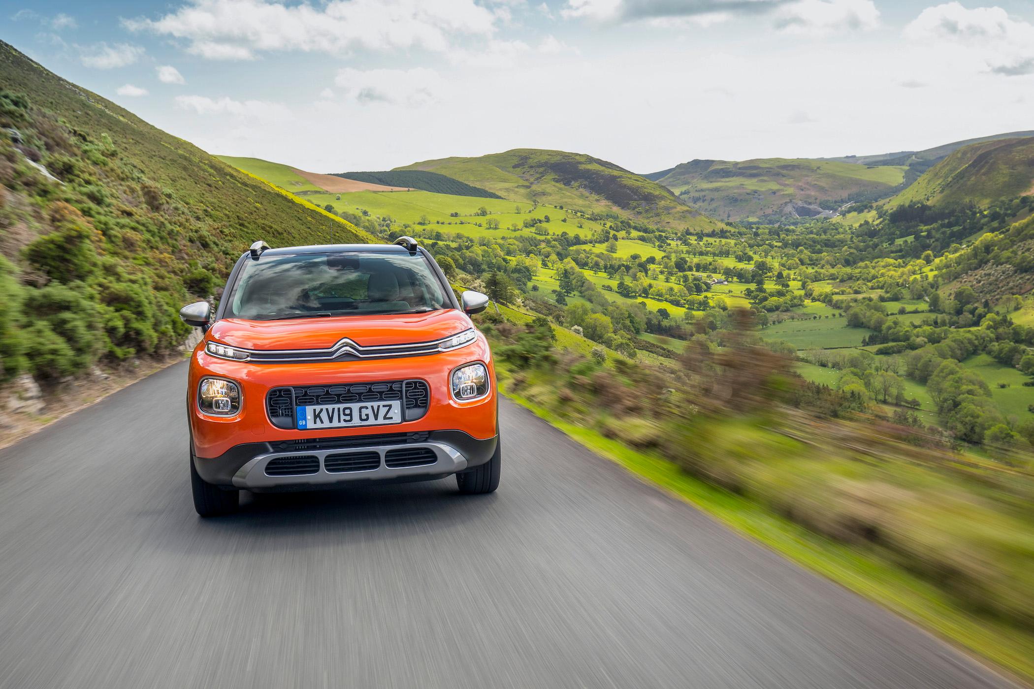 Orange Citroen C3 Aircross driving on a country road