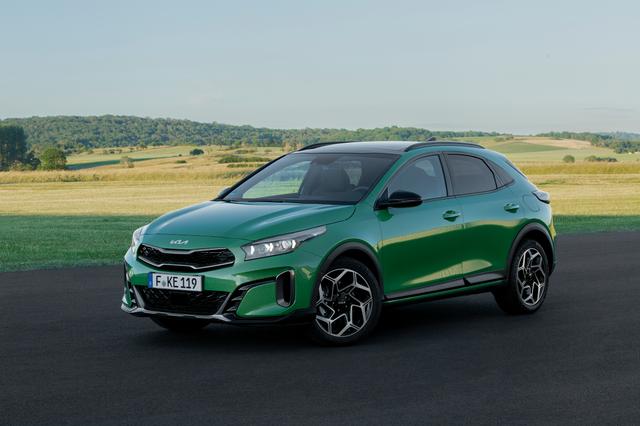 a light green kia xceed gt-line parked on tarmac in front of a green field