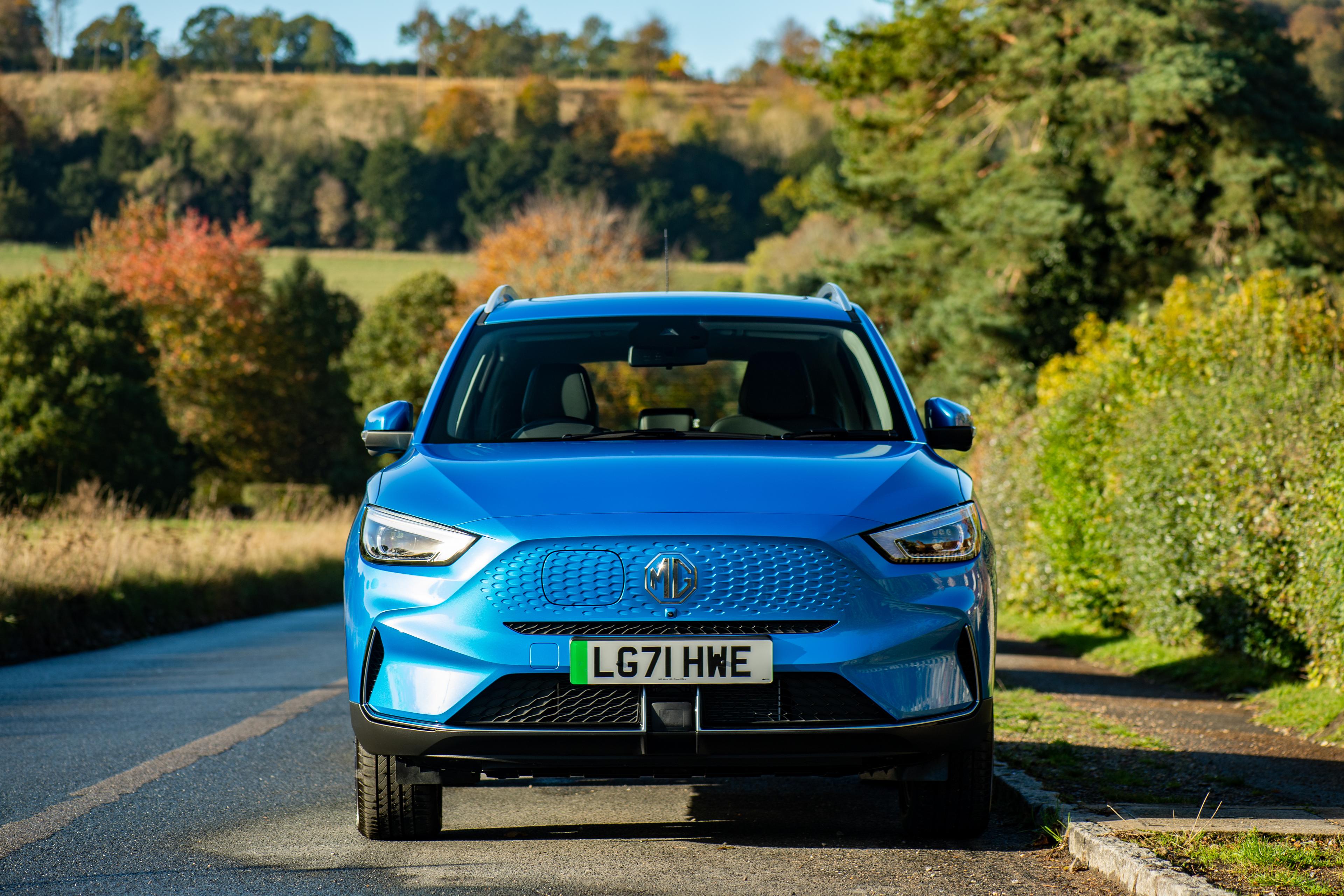 a battersea blue mg zs ev parked on a countryside road
